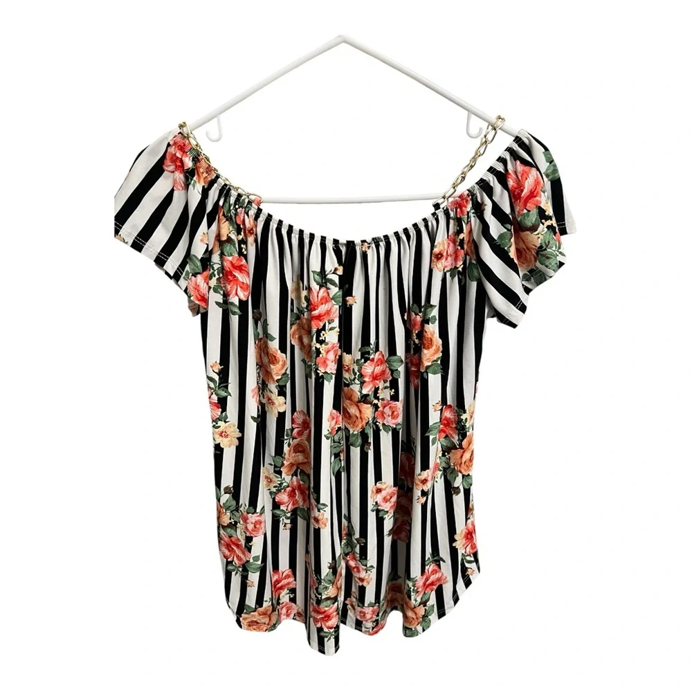 Women’s black and white blouse with floral print and detail with chain straps.